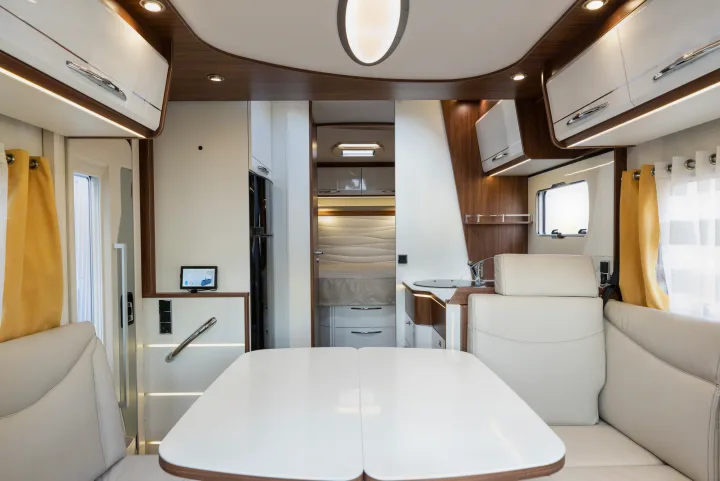 Modern rv rental interior showing a spacious dining area, integrated kitchen, and glimpse of the bedroom. A comfortable motorhome experience.. Pilote P746 A 2025