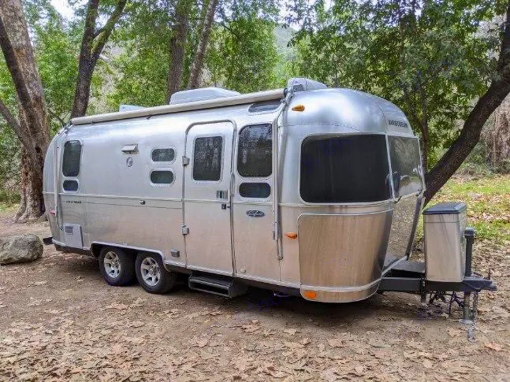 This Airstream travel trailer rv rental is ready for your next adventure, nestled in a peaceful, wooded campsite.. Airstream Safari 2008