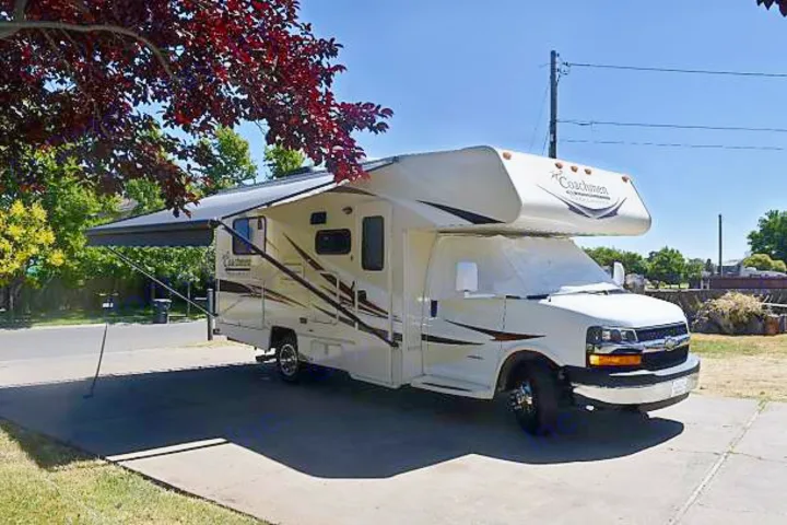 White Coachmen RV rental parked outdoors with awning extended, ready for a trip.. Coachmen Freelander 2016