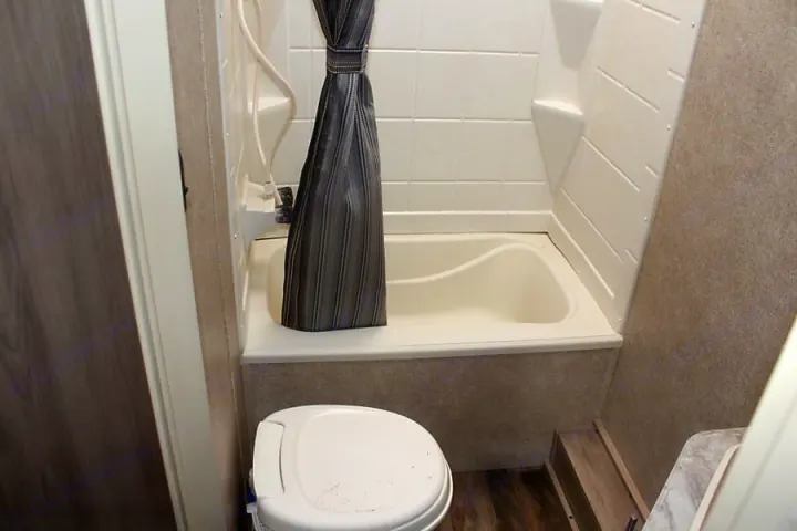 RV rental bathroom: Compact space featuring a toilet and a small tub/shower combo with a curtain.. Coachmen Catalina 2019