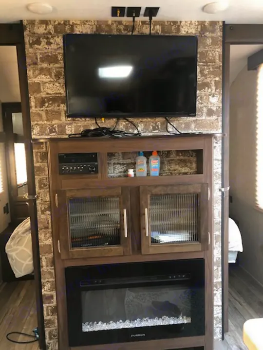 Cozy RV rental interior with mounted TV, media center, and Furrion electric fireplace. Perfect for relaxation.. Forest River Cherokee Grey Wolf 2019