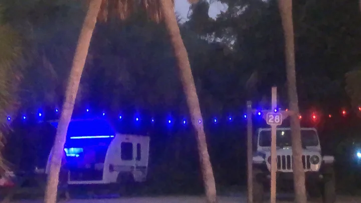 RV rental illuminated by blue interior lights, parked at campsite 28 with a Jeep, framed by palms & festive string lights.. InTech RV InTech RV Trailer 2021