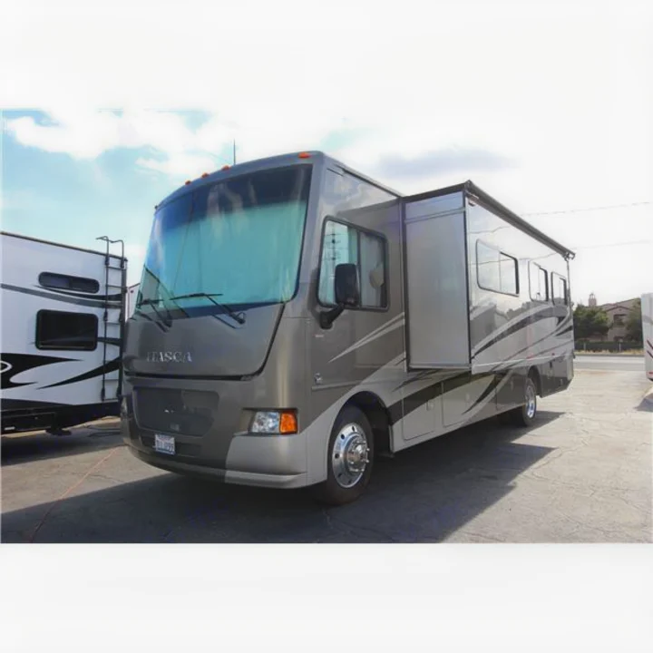 Grey Itasca RV rental motorhome with its side slide-out extended, parked outdoors.. Itasca Sunstar 2014