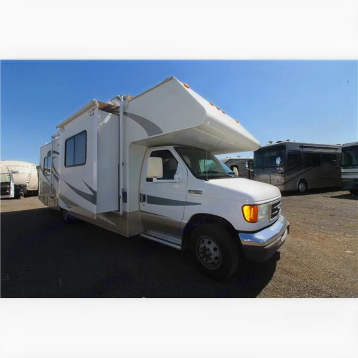 A white Class C RV, ideal for your next rv rental. Shows an extended side slide-out, parked outside on a sunny day.. Thor Four Winds 2007