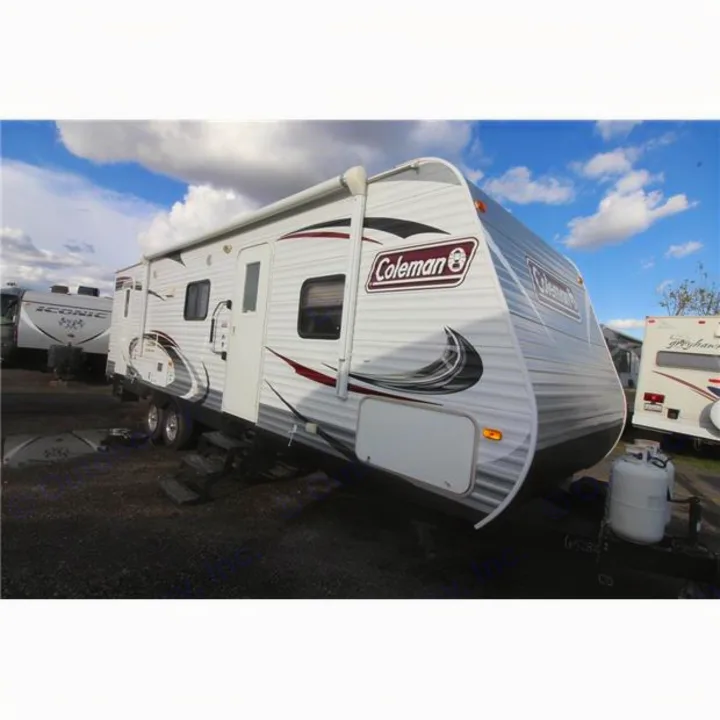 White Coleman travel trailer RV with black/red graphics, awning, and propane tanks, perfect for rv rental.. Dutchmen Coleman 2014