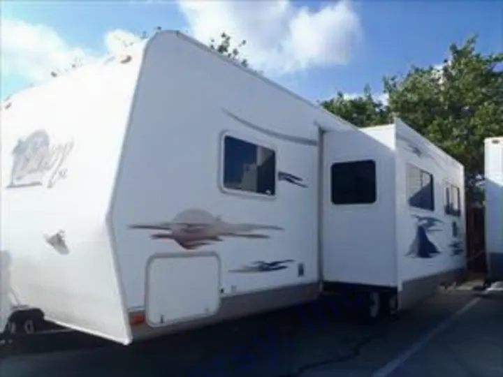 White travel trailer RV with extended slide-outs, ready for your next rv rental. Parked outdoors on a sunny day.. Holiday Rambler Savoy 2007