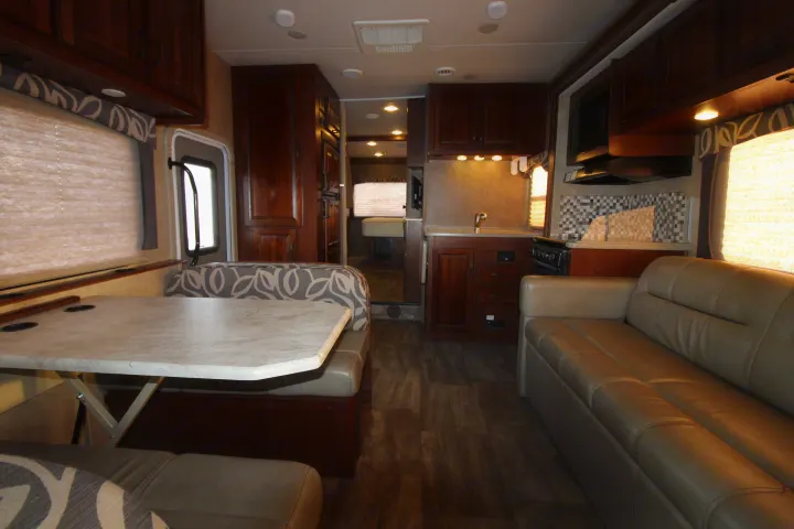 Modern RV rental interior featuring a kitchen, dinette, and living area with comfortable seating and dark wood accents.. Forest River Forester 2016