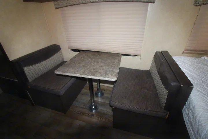 RV rental interior featuring a cozy dinette with seating and table, plus a glimpse of the bed and window.. Forest River Sonoma 2017