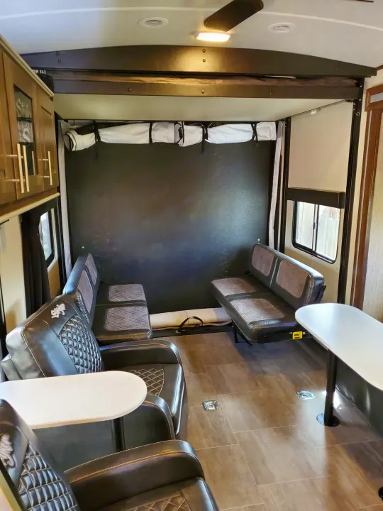 Inside a spacious RV rental toy hauler, featuring a garage, fold-down benches, tables, and a ceiling bed.. Cruiser Rv Corp Stryker 2020