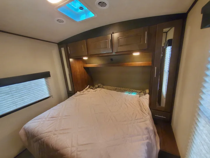 Cozy RV rental bedroom featuring a comfortable bed, overhead cabinets, and a bright skylight, ready for your next adventure.. Cruiser Rv Corp Stryker 2020