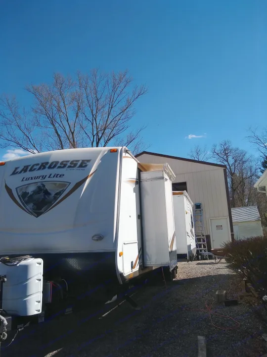LaCrosse Luxury Lite RV rental travel trailer parked with slide-out extended on gravel under a clear blue sky.. Prime Time Lacrosse 2013
