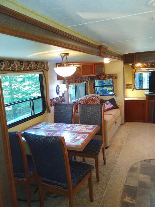 This RV rental offers a well-lit living/dining area with a wooden table, four chairs, and a comfortable sofa by large windows.. Prime Time Lacrosse 2013