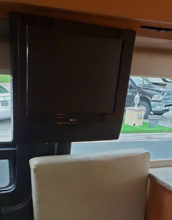 Inside an RV rental, featuring a mounted TV with a built-in soundbar above light-colored dinette seating.. ERA Era 2010