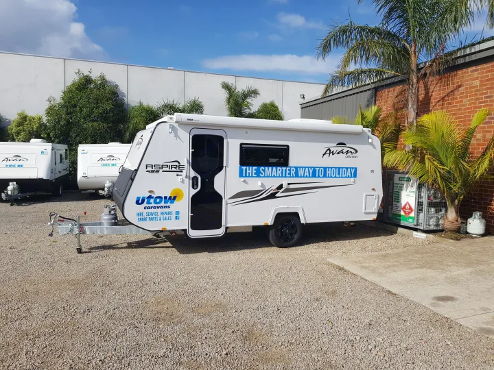 White Avan caravan at Utow Caravans, an RV rental, sales, and service business, parked on a gravel lot.. Avan Aspire 499 Bunk 2020