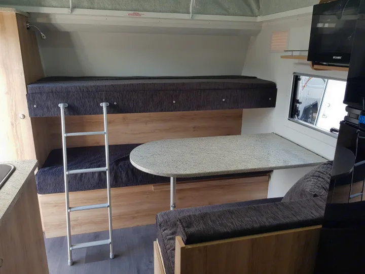 This RV rental's interior boasts comfortable bunk beds, a ladder, and a granite-top dining area with a microwave.. Avan Aspire 499 Bunk 2020