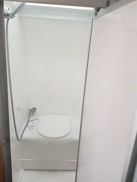 Clean, compact RV rental wet bath, featuring a toilet, bidet, and shower hose in a bright white interior.. Avan Aspire 499 Bunk 2020