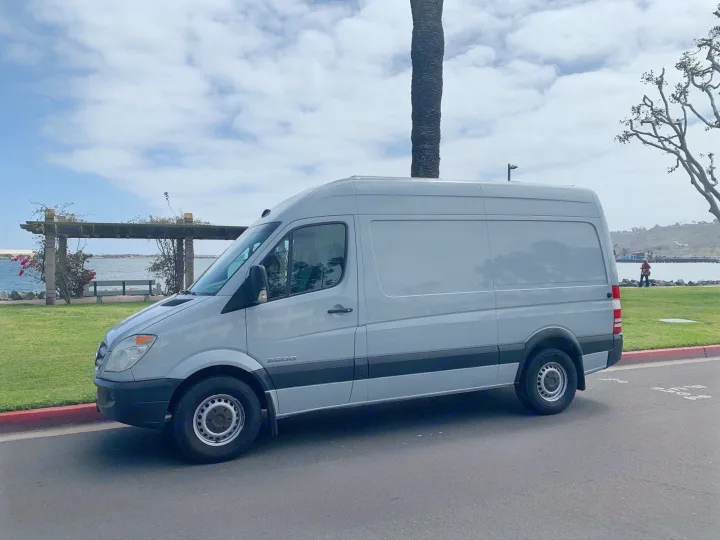 Light gray Sprinter 2500 van, a spacious RV rental, parked by the scenic oceanfront for travel.. Dodge Sprinter Van 2007
