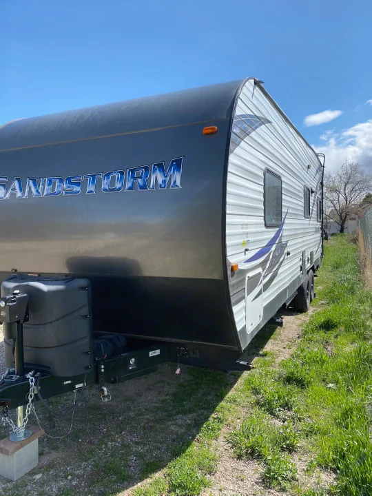 Sandstorm travel trailer RV rental parked outdoors under a clear sky. Perfect for your next adventure.. Forest River Sandstorm 2017