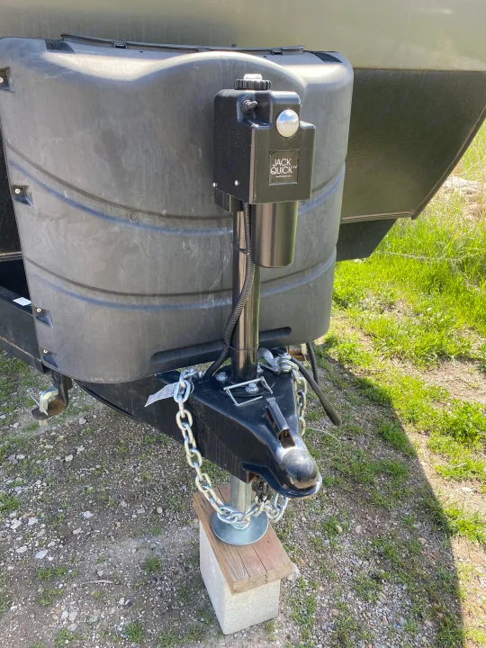 RV rental trailer's front hitch, electric jack, and propane tank cover, ready for towing.. Forest River Sandstorm 2017