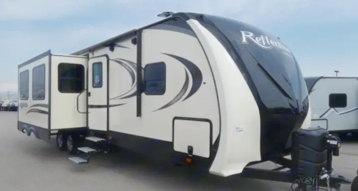 A spacious cream & black fifth-wheel RV with slides extended, ready for your next rv rental adventure. Steps deployed.. Grand Design Reflection 2019