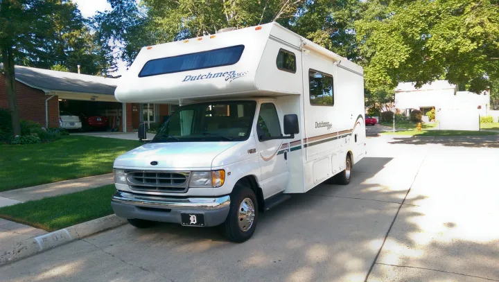 White Dutchmen Express Class C RV rental, a Ford E-450 motorhome, parked on a residential street.. Dutchmen Other 2001