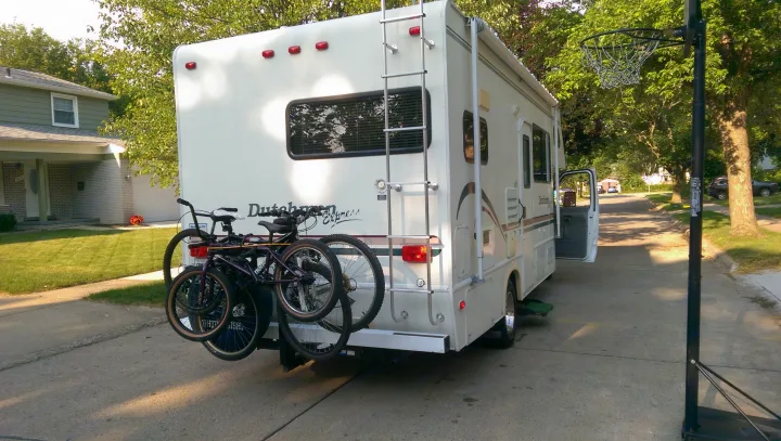 White Dutchmen Express RV rental with bicycles on a rear rack, parked on a paved area, ready for adventure.. Dutchmen Other 2001