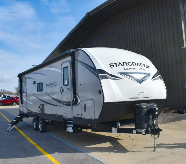 Gray and white Starcraft Super Lite travel trailer (RV) rental, parked outdoors with awning extended.. Starcraft Travel Trailer 2020