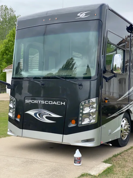 Front of a large, clean dark gray Sportscoach motorhome, perfect as an RV rental. A detailing product bottle sits on the driveway.. Coachmen Sportscoach 2018