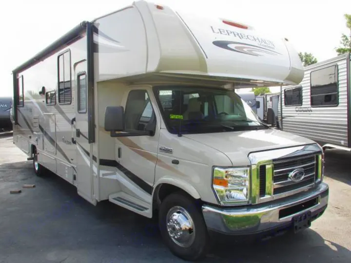 Spacious beige Ford Class C RV, labeled "LEPRECHAUN", with an extended awning, ready for your next rv rental trip.. Coachmen Leprechaun 2020