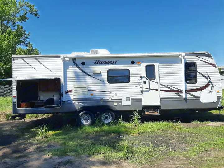 White Hideout travel trailer parked outdoors, perfect for an RV rental adventure under a clear sky.. Keystone RV Hideout 2014