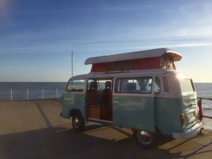 Classic VW camper van with pop-top, side door open, parked on a pier overlooking the ocean. Perfect for an RV rental.. Volkswagen 2.0L T2 Late Bay 1975