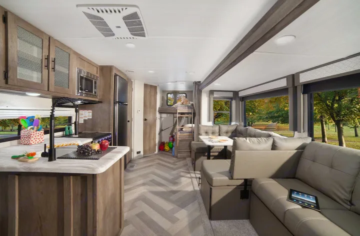 Modern RV rental interior: Kitchen, lounge with large windows, and bunk beds, offering a cozy home on wheels.. Forest River Salem 2021