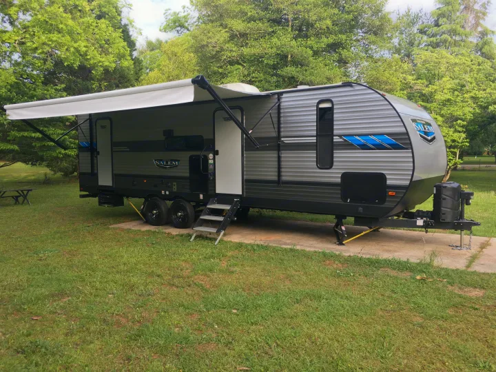 Spacious Salem travel trailer (RV) for rv rental, parked with awning extended at a serene campsite.. Forest River Salem 2021