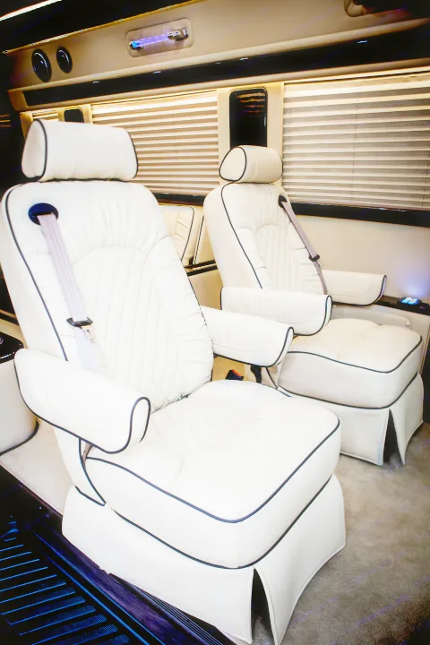 Luxurious RV rental interior: Plush white leather captain's chairs with elegant design, offering ultimate travel comfort.. Mercedes Entertainer 2020
