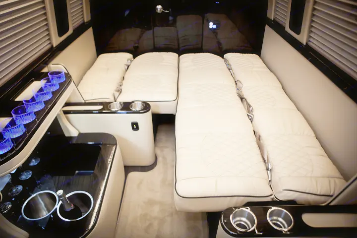 Luxurious RV rental interior: four plush, reclinable seats for sleeping/lounging, plus illuminated bar amenities.. Mercedes Entertainer 2020