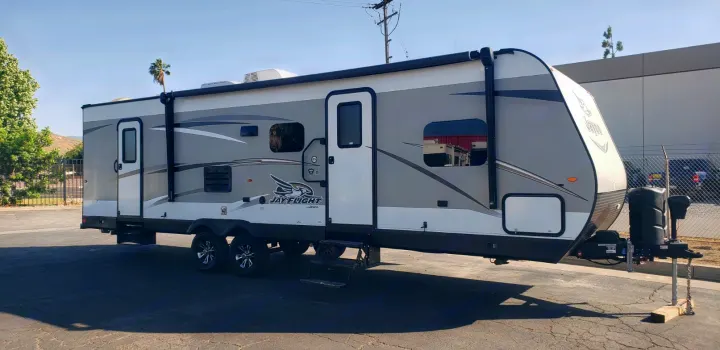 A gray and white Jayco Jay Flight travel trailer parked, ready for your next rv rental trip.. Jayco Jay Flight 2019