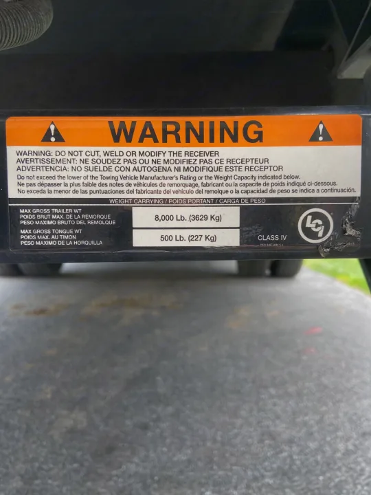 An RV rental's hitch capacity label: Max trailer 8,000 lbs, tongue 500 lbs. Essential for safe towing.. Thor Freedom Elite 2020