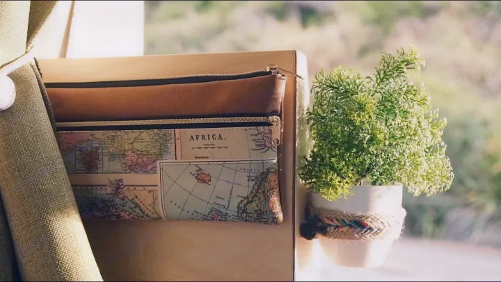 RV rental interior featuring map-print storage bags and a decorative plant by the window.. Toyota Voxy 2006