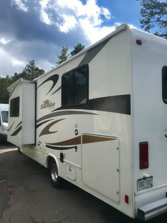 White Sunseeker RV rental with a side slide-out extended, featuring brown graphics. Perfect for your next outdoor adventure.. ForestRiver Sunseeker 2012