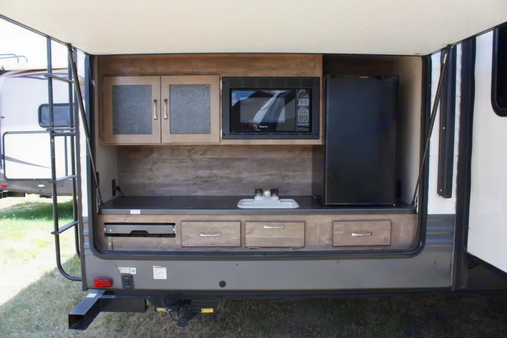 Experience outdoor cooking with this rv rental's built-in kitchen: microwave, fridge, sink, and pull-out grill.. Palomino Puma 2018