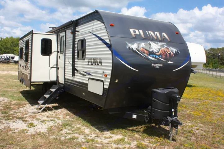Black & white Puma travel trailer, with a slide-out and steps deployed, perfect for your next RV rental adventure.. Palomino Puma 2018