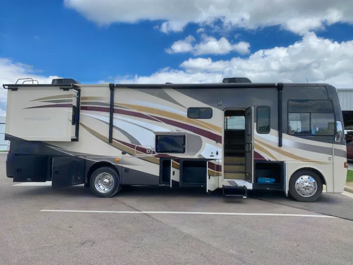 Spacious Miramar RV rental parked outdoors with slide-out extended and storage compartments open, ready for adventure.. Thor Motor Coach Miramar 2014