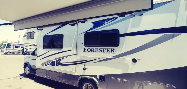 Side view of a white and blue Forester motorhome, a spacious RV rental with its awning extended.. Forest River Other 2018