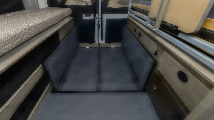 RV rental: Camper van interior with smart storage, including under-bed netting, floor compartments, and cabinetry.. Winnebago Solis 2021