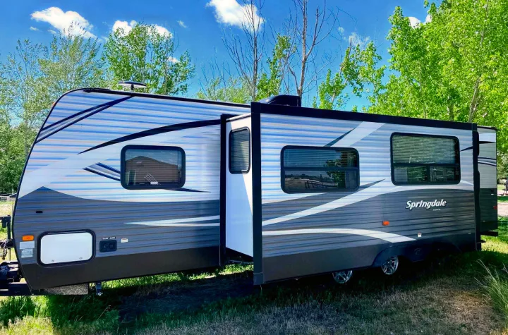 Springdale travel trailer with slide-out extended, perfect for your next rv rental adventure under a clear sky.. Keystone Springdale 2017