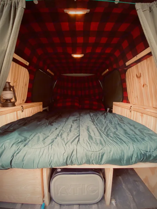 Experience comfort in this **rv rental**! Features a cozy red plaid interior, full bed, wood trim, and cooler storage.. Ford Custom Transit 2011