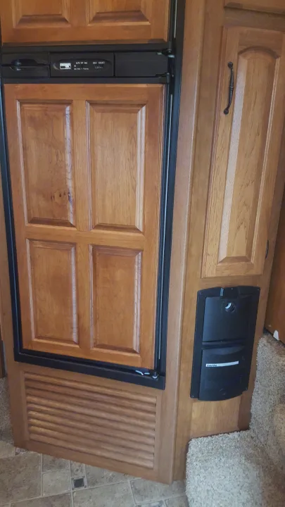 RV rental interior: Wood-paneled refrigerator with control panel and built-in InterVac system.. Keystone Montana 2011