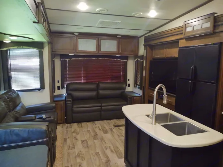 Cozy RV rental interior: kitchen island, plush seating, and ample storage for comfortable travel.. Keystone Cougar 2019