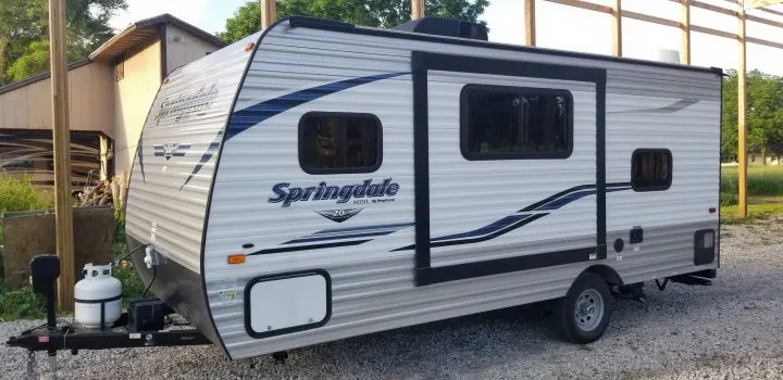 This Springdale Mini travel trailer, a white RV with blue accents, is perfect for your next rv rental camping trip.. Keystone Springdale 2019