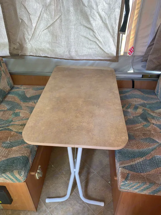 This RV rental's dinette features a removable table between two patterned bench seats, under canvas pop-up walls.. Coachmen Sport 2007